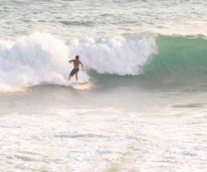 a man riding a wave on a surfboard in the ocean at brun & browns in Matara