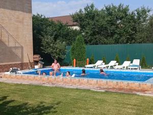 a group of people in a swimming pool at Дом с подогреваемым бассейном in Liski