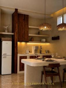 a kitchen with a white refrigerator and a counter at CASA Ohana Private Villa in Thai Muang