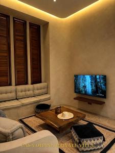 a living room with a flat screen tv on the wall at CASA Ohana Private Villa in Thai Muang