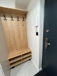 a walk in shower with a wooden door in a bathroom at Apartmán JT in Vyšné Opátske