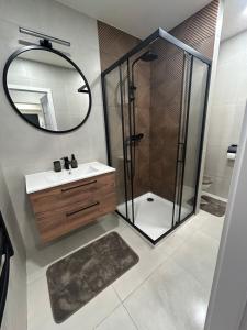 a bathroom with a shower and a sink and a mirror at Apartmán JT in Vyšné Opátske