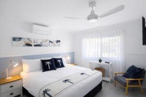 a bedroom with a large bed with black and white pillows at Lakeside Views in Urangan