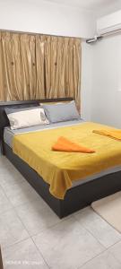 a bed with an orange blanket on top of it at Hot Spring Residential B in Kuala Lumpur