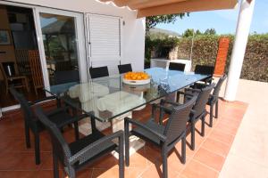 a glass dining table and chairs on a patio at Villa Mara in Sant Jordi