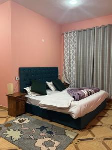 a bedroom with a bed in a room with pink walls at Julley Jispa in Jispa