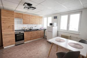 a kitchen with white appliances and a table with chairs at Ubytování U Ropáků in Horní Slavkov