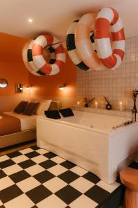 a room with a bathtub and a bed and a room with a bed at La Pimenta - SPA privatif & expérience immersive in Dole +59 photos
