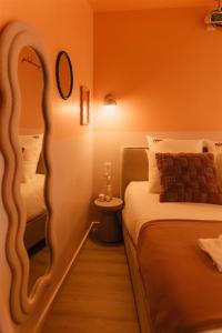 a small room with a bed and a mirror at La Pimenta - SPA privatif & expérience immersive in Dole