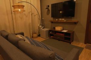 a living room with a couch and a flat screen tv at Layag La Union in san juan la union