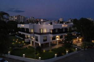 a white building with a sign on it at night at De Suite Hotel in Antalya
