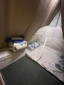 a small bed in a tent with an umbrella at Canopy Haven in Siliguri