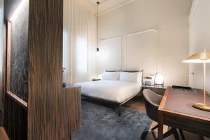 a hotel room with a bed and a desk at Hotel Mercer Sevilla 5 GL in Seville