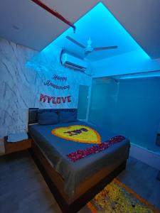 a room with a bed with a blue light at Hotel The World in Surat