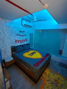 a bedroom with a bed with a happy anniversary sign on it at Hotel The World in Surat