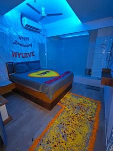 a bedroom with a bed with a blue light at Hotel The World in Surat
