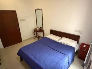 a bedroom with a blue bed and a mirror at Fisherspot Villa in Weligama