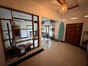 a room with a room with a surfboard on the wall at Fisherspot Villa in Weligama