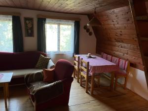 a living room with a table and a couch at Chata Buková in Brezina
