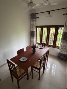 a dining room with a wooden table and chairs at Fisherspot Villa in Weligama +11 photos