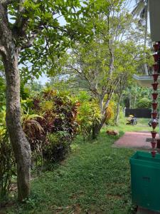 a garden with trees and a dog laying on the grass at Fisherspot Villa in Weligama