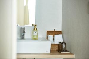 a bathroom counter with a sink and a mirror at Izumisano Center Hotel Kansai International Airport in Izumi-Sano +48 photos