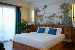 a bedroom with a large white bed with blue pillows at De Suite Hotel in Antalya +42 photos
