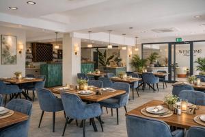 a restaurant with wooden tables and blue chairs at De Suite Hotel in Antalya