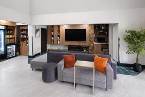 a living room with a couch and a tv at Wingate by Wyndham Myrtle Beach At Outlets in Myrtle Beach