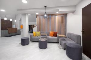 a lobby with a couch andools in a room at Wingate by Wyndham Myrtle Beach At Outlets in Myrtle Beach +40 photos
