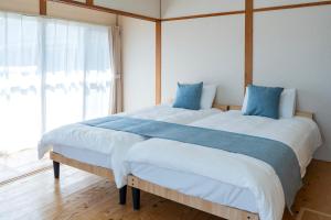 a bedroom with a large bed with blue pillows at ひなたの宿結 in Miyazaki