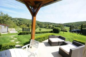 a patio with chairs and a table and a swing at Proche de Rocamadour in Montcléra