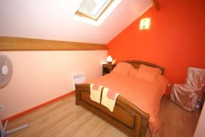 a bedroom with a bed with an orange wall at Proche de Rocamadour in Montcléra