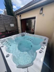 a hot tub sitting on top of a patio at Sylina Spa avec Jacuzzi Privé in Villeblevin