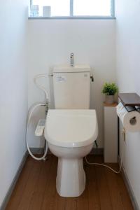 a white toilet in a bathroom with aperature at ひなたの宿結 in Miyazaki +35 photos