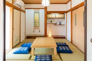 a small room with a table and blue pillows at ひなたの宿結 in Miyazaki