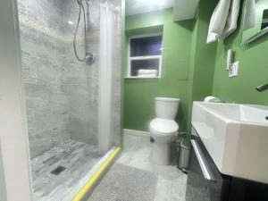 a bathroom with a shower and a toilet and a sink at Cozy Coastal Retreat Close to Beach Park in Port Moody +10 photos