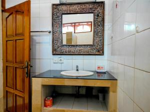 a bathroom with a sink and a mirror at Kaia Lovina Guest House in Lovina