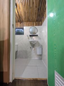 a bathroom with a sink and a mirror at Jadens Guesthouse in Siquijor