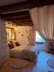 a bedroom with a bed in a stone wall at Gite des arches in Saint-Nectaire