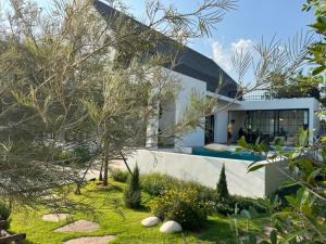 a house with a garden in front of it at Oxygen Cloud Khaoyai Managed by OHS in Ban Bung Toei