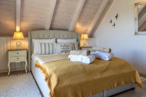 a bedroom with a bed with blue pillows on it at Lovassy Lodge Vendégház in Lovas
