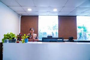 a woman standing behind a counter in an office at Tree Inn Jubilee in Hyderabad