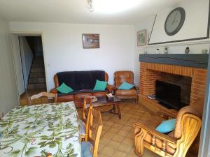 a living room with a couch and a fireplace at Gîte des deux Moulins en Périgord Vert in Grand Brassac