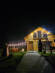 a wooden house at night with lights on it at Domki pod Bukowym Lasem in Wańkowa