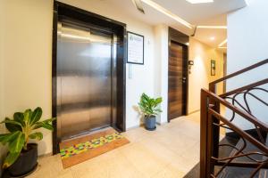 an elevator in a hallway with two plants at Treebo Calangute Beach Stay in Calangute +32 photos