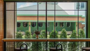 a large glass window with a table and chairs at Happihaus Hotel Bangkok in Bangkok