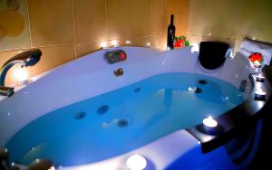 a blue tub in a room with a bottle of wine at Relax pozar in Kato Loutraki +28 photos