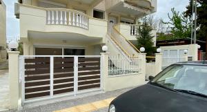 a car parked in front of a house with a gate at Nikol's central suite 2 in Nea Peramos