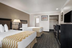 a hotel room with two beds and a flat screen tv at Travelodge by Wyndham Eureka in Eureka +51 photos